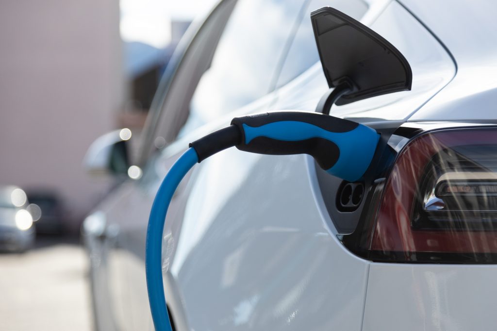 EV electric car pluged charging at a recharge station in the city